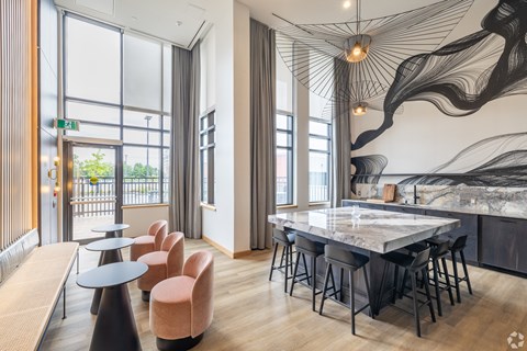 a dining area with a marble table and chairs and a large window